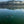 Load image into Gallery viewer, a group of 5 people paddle boarding across a very flat ocean with green mountains in the background